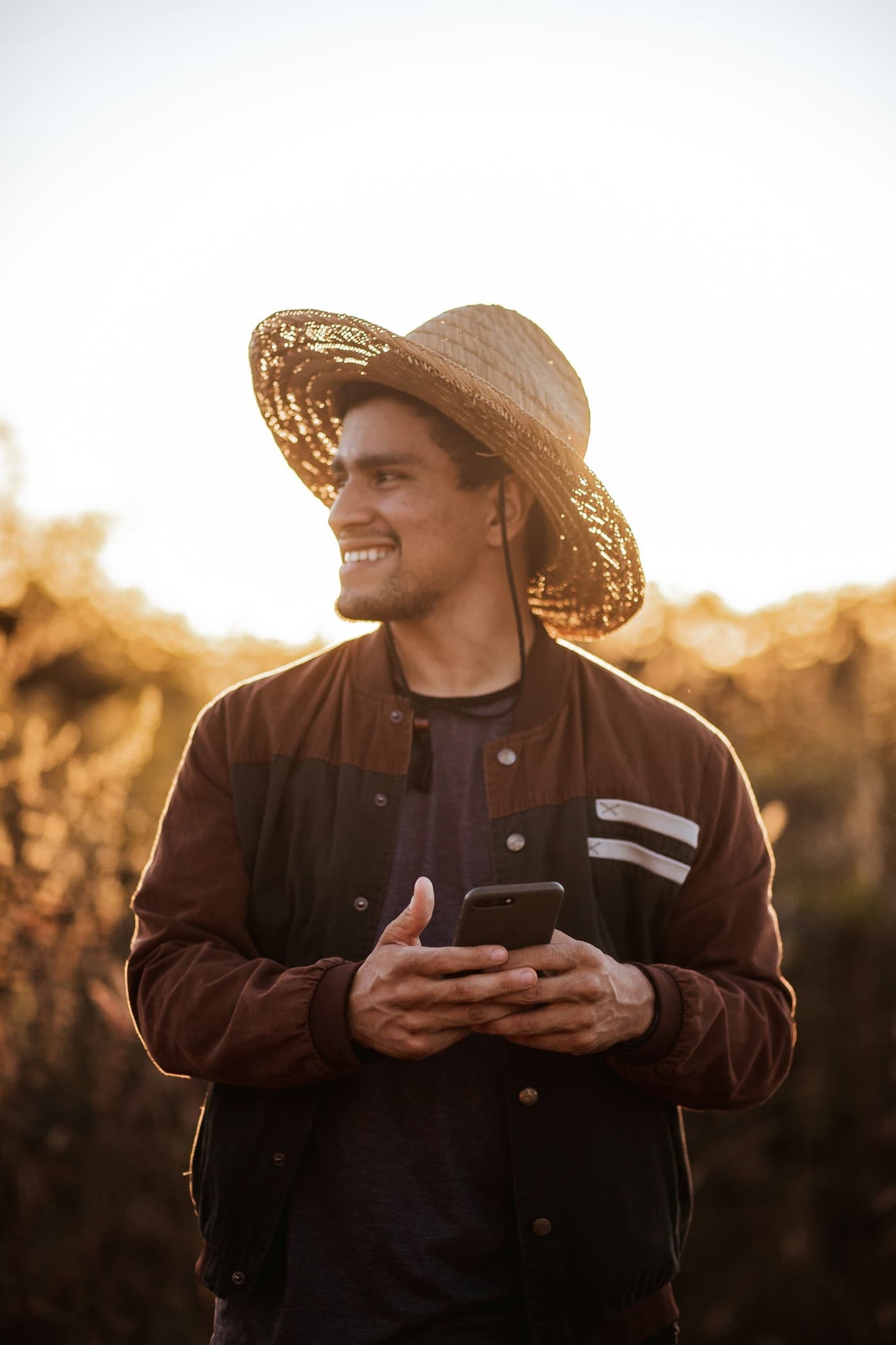 Engenheiro agrónomo de chapéu, com o telemóvel na mão, ao fim da tarde