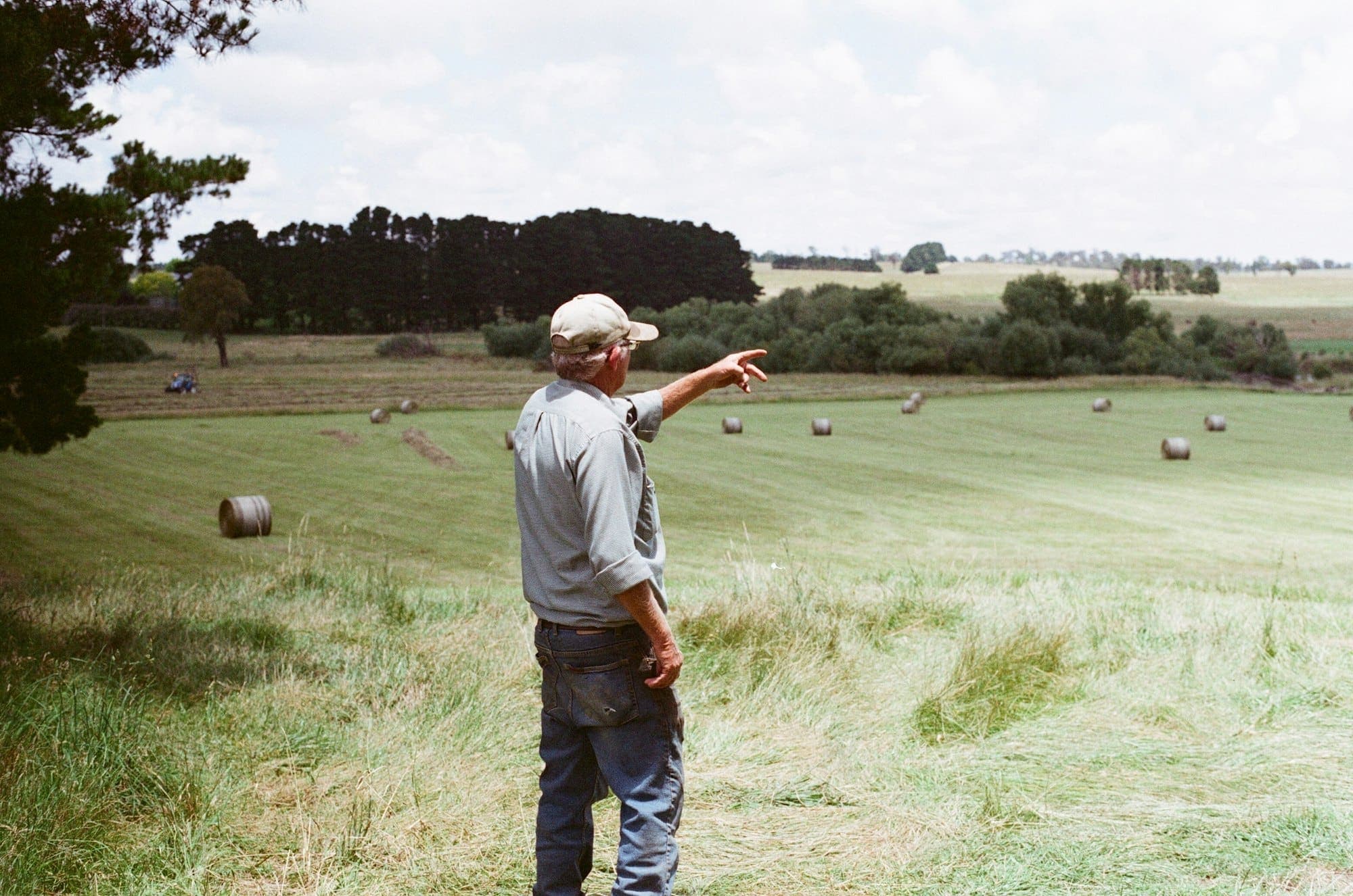 Agricultor no campo a apontar para as parcelas
